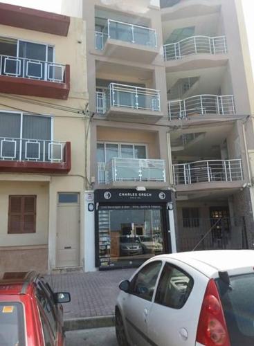 a white car parked in front of a building at Panorama Mediterranea in St. Paul's Bay