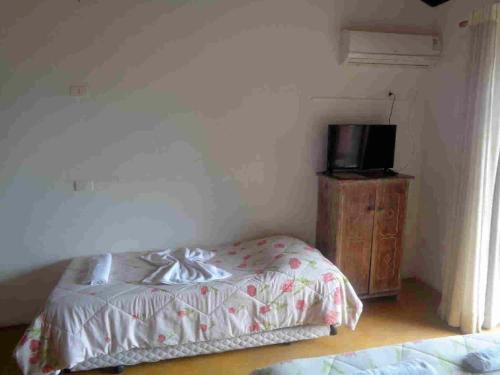 a bedroom with a bed and a tv on a dresser at Pousada Mareilha in Ilhabela