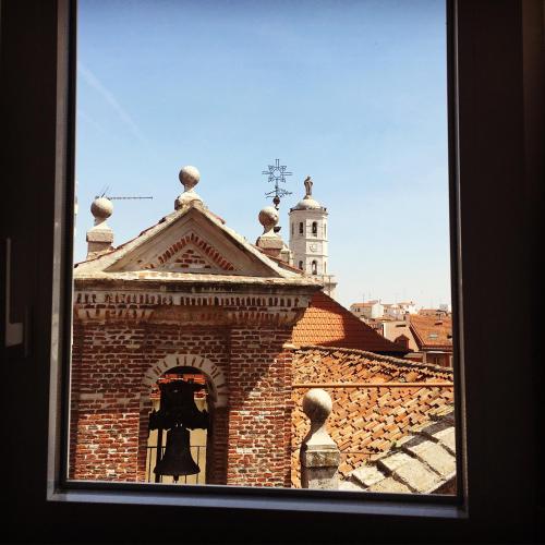 a window of a brick building with a bell tower at AIRVA: Apartamento Teresa Gil in Valladolid