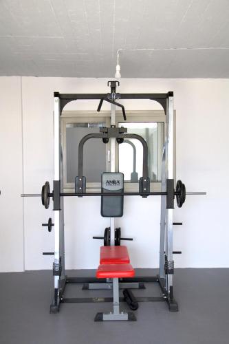 a gym with a red chair in a room at Belvedere Suites Korfos in Korfos
