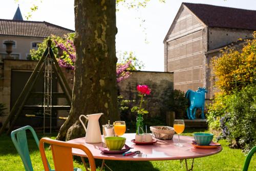a pink table with drinks on it in a yard at Le Clos de l'Abbaye in Cluny