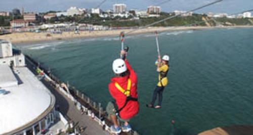 two people are in the air over the water at Hartford Court in Bournemouth