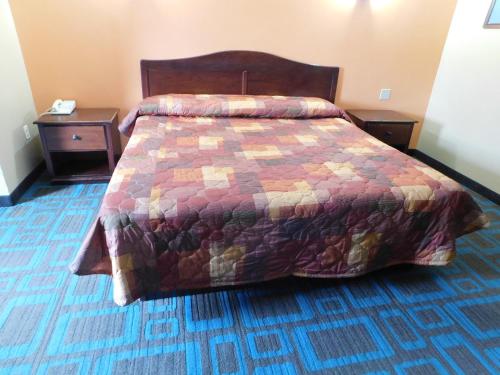 a bedroom with a bed with a colorful quilt at Hotel Vicenza in Monmouth Junction