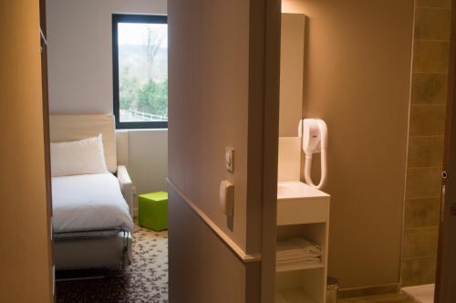 a small room with a bed and a window at ibis styles Villeneuve Sur Lot in Villeneuve-sur-Lot