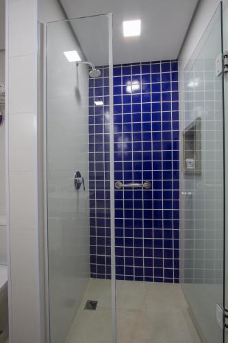 a bathroom with a shower with blue tiles at Le CanarD Joinville in Joinville