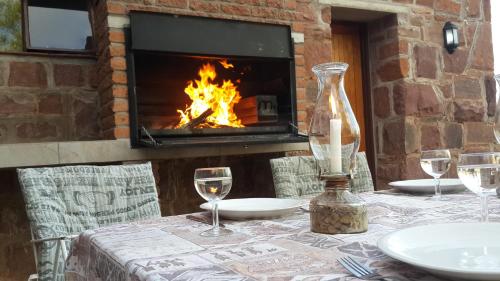 a table with wine glasses and a fireplace at Duwisib Guest Farm in Duwisib