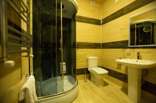 a bathroom with a shower and a toilet and a sink at Ire Palace in Batumi