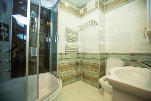 a bathroom with a shower and a toilet and a sink at Ire Palace in Batumi