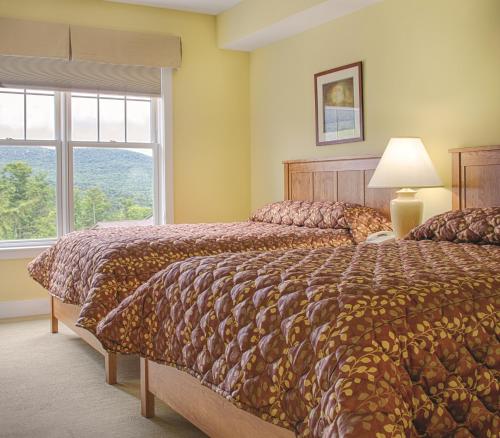 a bedroom with two beds and a window at Wyndham Smugglers Notch in Jeffersonville