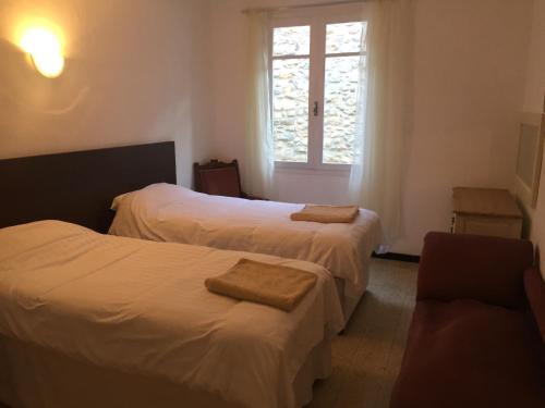une chambre d'hôtel avec deux lits et une fenêtre dans l'établissement Maison les Ramparts, à Villefranche-de-Conflent