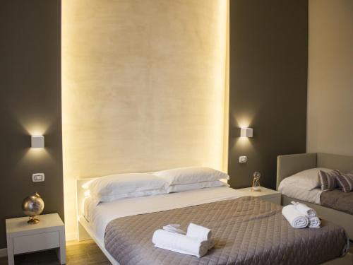 a bedroom with a bed with two towels on it at La Banchina Holiday Rooms in Trani