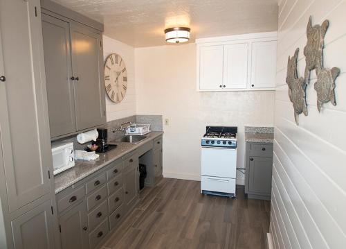a kitchen with white cabinets and a stove top oven at Capitola Venetian Hotel in Capitola