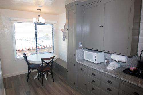 a kitchen with a table and a counter with a microwave at Capitola Venetian Hotel in Capitola