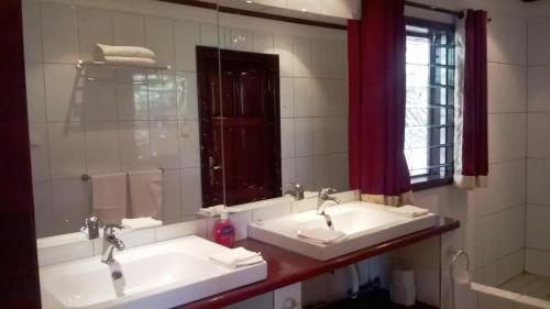 a bathroom with two sinks and a mirror at White Horse Residence in Tanji