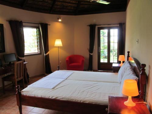 a bedroom with a large bed and a red chair at White Horse Residence in Tanji