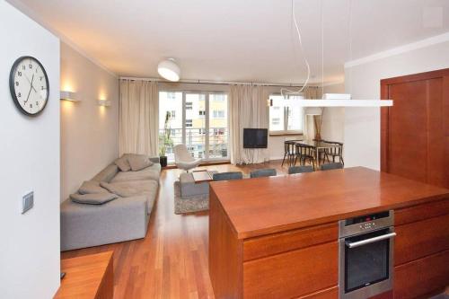 salon z kuchnią oraz salon z zegarem w obiekcie Apartament Lato w Gdyni w mieście Gdynia