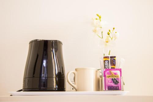 une cafetière assise sur une étagère à côté d'un vase dans l'établissement Antico Corso Charme, à Cagliari