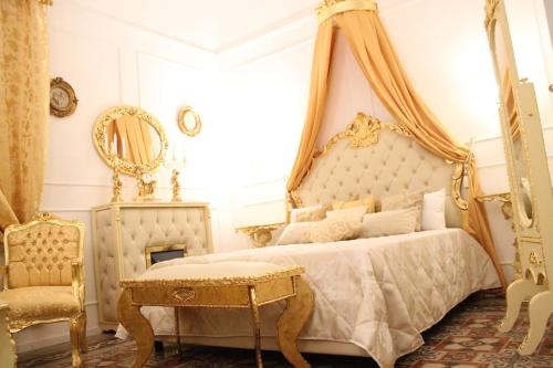 1 dormitorio con cama con dosel, mesa y silla en DONNA LUCREZIA b&b Boutique Hotel Style, en Bisceglie