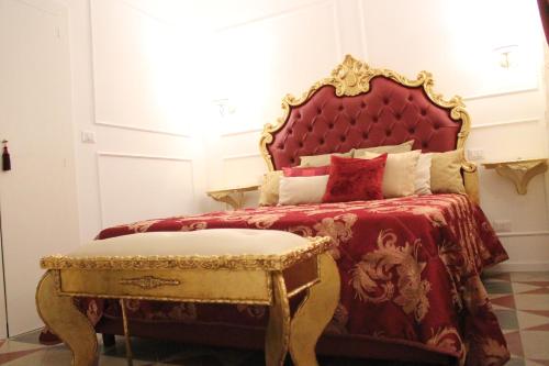 1 dormitorio con cama con cabecero rojo y taburete en DONNA LUCREZIA b&b Boutique Hotel Style, en Bisceglie