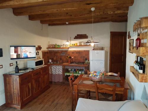 a kitchen with a table and a kitchen with a refrigerator at La Chintana in Palmadula