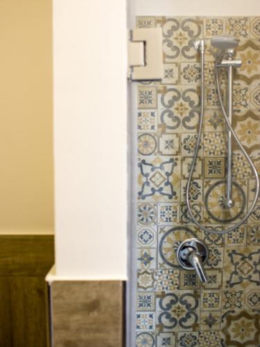 a shower in a bathroom with blue and white tiles at La Banchina Holiday Rooms in Trani