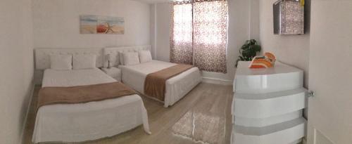 a white bedroom with two beds and a window at Sunny Isles Ocean Reserve Condo Apartments in Miami Beach