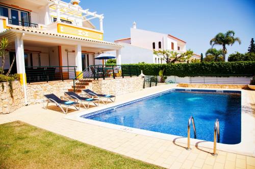 a swimming pool in front of a villa at Villa Clara Premium by Sunny Deluxe in Albufeira