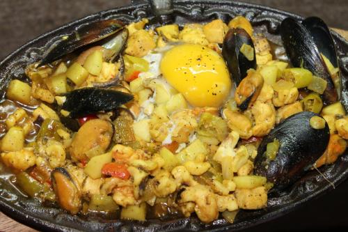a plate of food with an egg on top at Deep Forest Garden Hotel in Puerto Princesa City