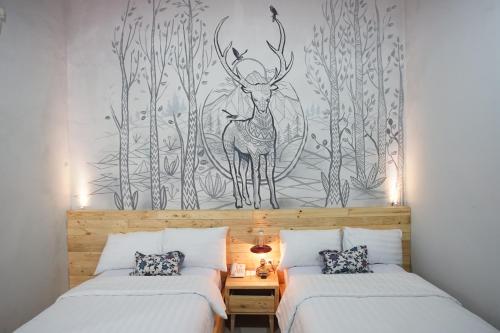 a bedroom with two beds and a mural of a deer at Omah Njonja Bed & Brasserie in Yogyakarta