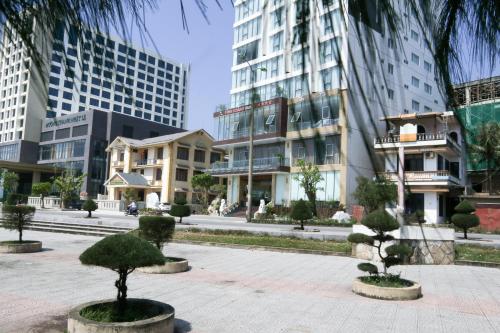 a courtyard with trees and buildings in a city at Vinh Hoang Hotel in Dong Hoi