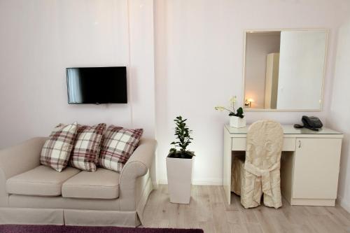 a living room with a chair and a mirror at Hotel Bellevue Trogir in Trogir