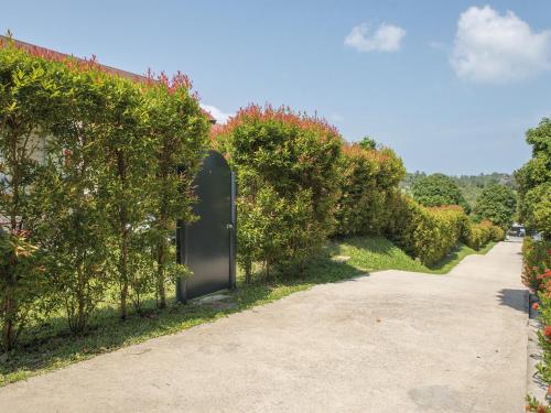 a black door in a hedge with a driveway at Moon Cottage in Choeng Mon Beach