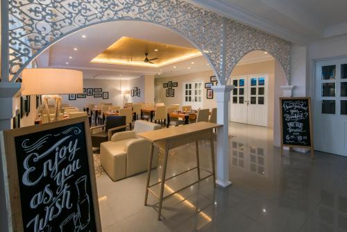 a restaurant with an archway and tables and chairs at Yan's House Hotel in Kuta