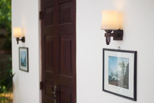 a door and a picture on a wall with lights at Hotel La Felicita in Mirissa
