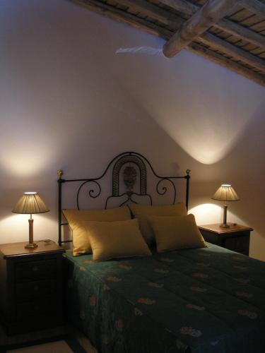 a bedroom with a bed with two lamps on tables at Casa da Silveirinha in Marvão