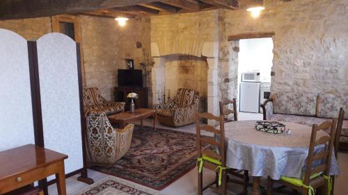 Zimmer mit einem Tisch und Stühlen sowie einer Küche in der Unterkunft Charmante Maison Pierres 1768 in Polisy