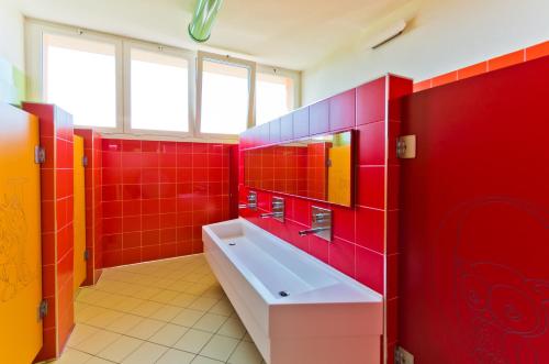 ein rotes Badezimmer mit einer Badewanne und einem Waschbecken in der Unterkunft Camping Lido in Lazise