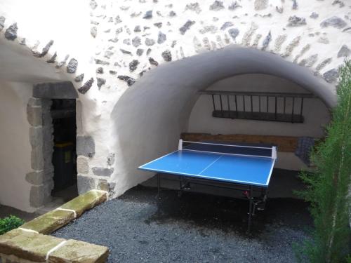 a blue ping pong table sitting in a tunnel at Les quatre provinces d'Irlande in Saint-Amant-Tallende