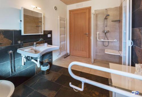 a bathroom with a sink and a shower at La Marmote Albergo Diffuso di Paluzza Testeons in Paluzza