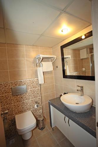 a bathroom with a sink and a toilet and a mirror at Yildizoglu Hotel in Samsun