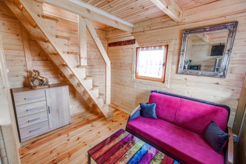 een woonkamer met een paarse bank in een tiny house bij Dom Koprowo in Międzywodzie