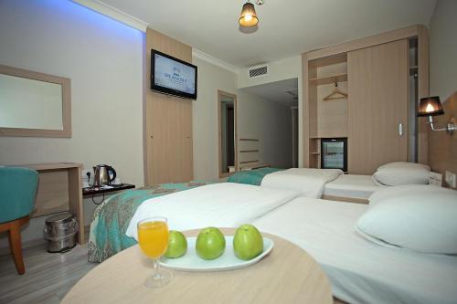 a hotel room with two beds and a plate of fruit on a table at Yildizoglu Hotel in Samsun