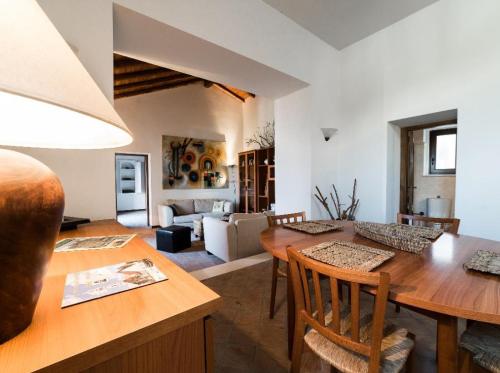 a kitchen and living room with a wooden table and chairs at TAORMINA - The Godfathers Little Mansion in Forza dʼAgro