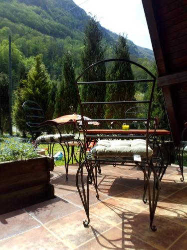 two chairs and a table on a patio with a mountain at Viola i Detelina Apartments in Perućac