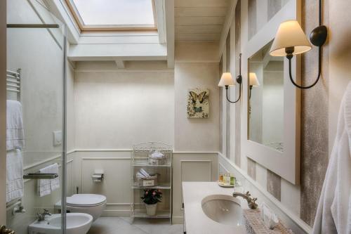 a bathroom with a sink and a toilet and a window at Relais Villa Vittoria in Laglio