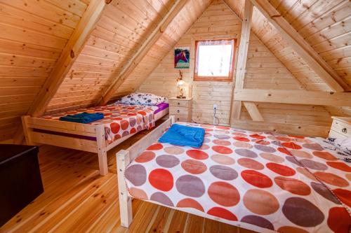 a bedroom with two beds in a log cabin at Dom Koprowo in Międzywodzie