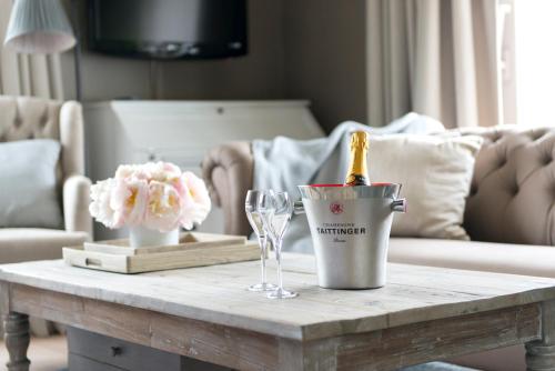 a table with a bottle of champagne and glasses on it at Lebeaubylivingroom Hotel in Knokke-Heist