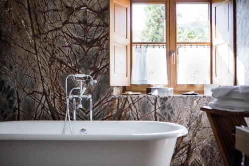 a bathroom with a bath tub and a window at La Bastide De Moustiers - Hôtel et Restaurant - Teritoria in Moustiers-Sainte-Marie