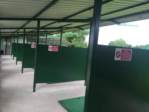 a row of green stalls in a building at Hillview Lodge in Armagh