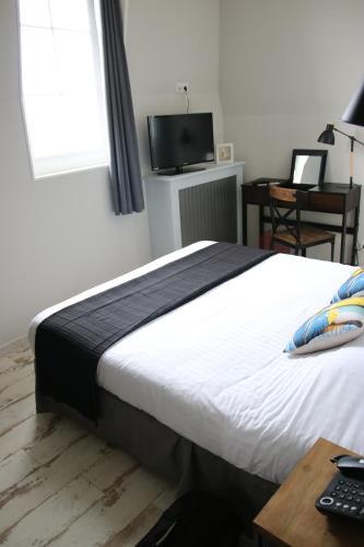 a bedroom with a bed and a desk and a television at Les Fregates in Veulettes-sur-Mer
